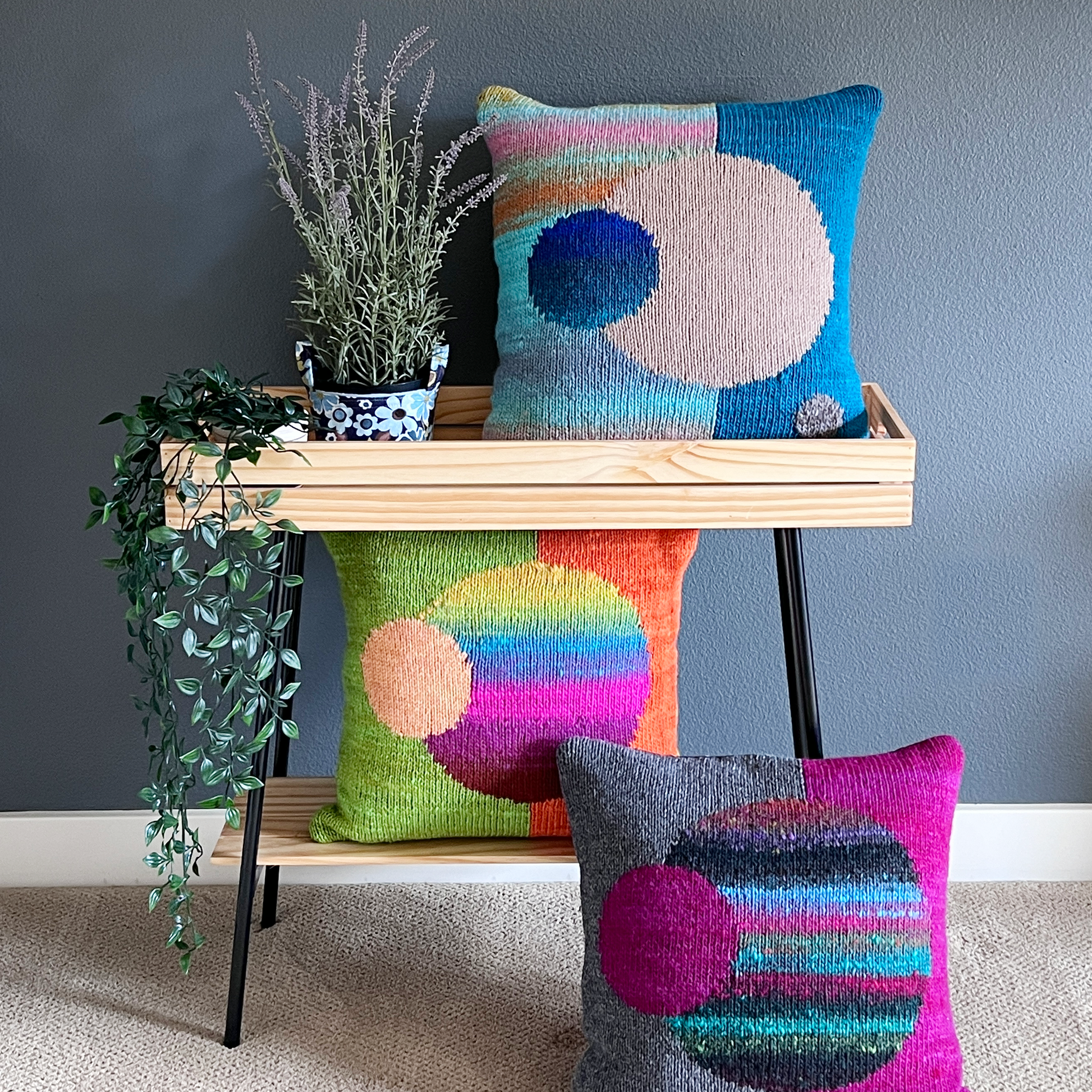 Three "Celestial Spheres" hand-knit pillows, two of which include Santa Cruz yarns paired with Noro's Kureyon and Malvinas.