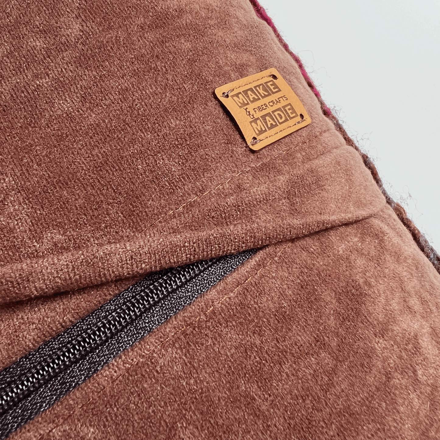 A black zipper hides beneath a 1 inch flap, rendering this hand-sewn pillow cover easy to remove for spot cleaning.