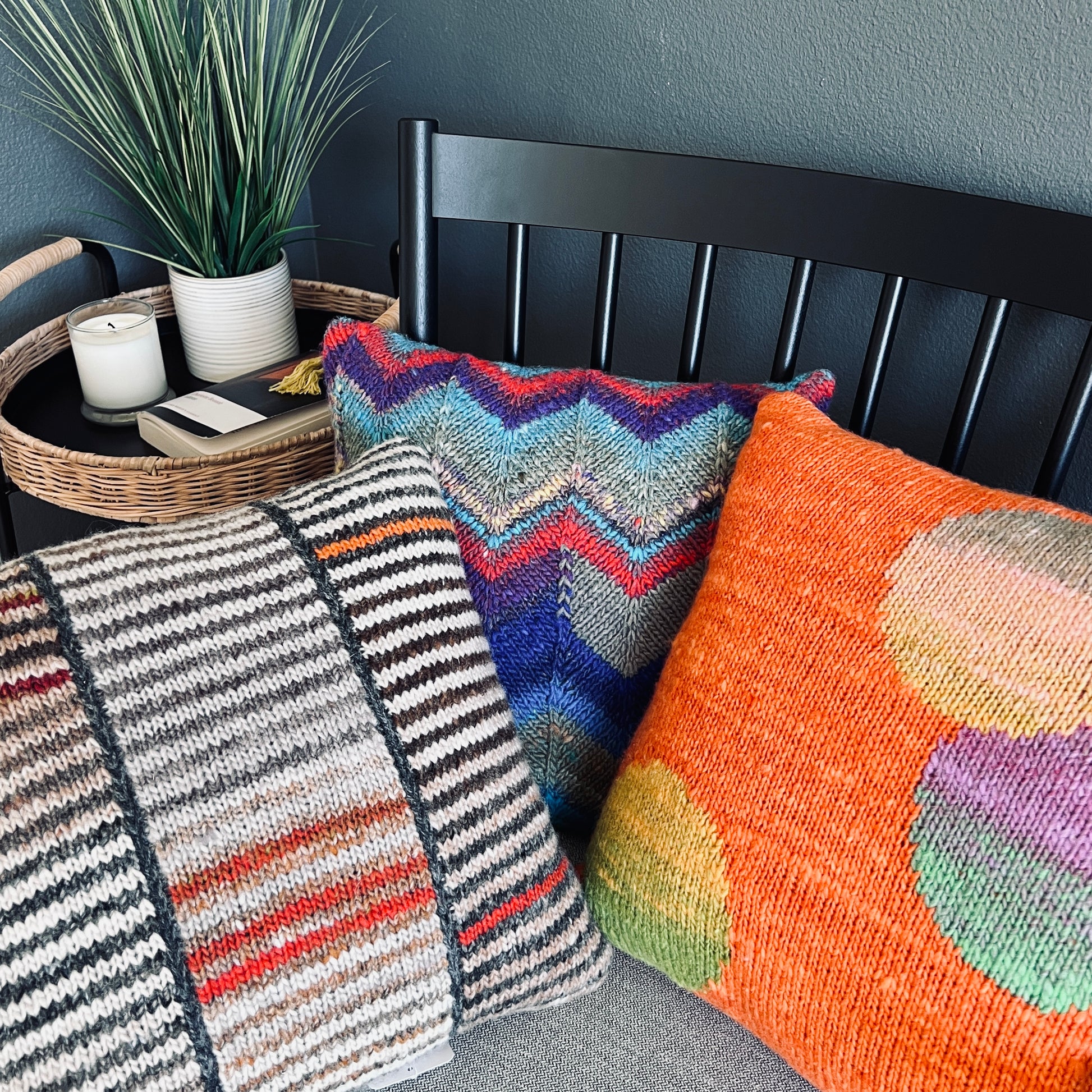 A close-up of three separate, hand-knit  pillows showcase the expert craftmanship of Susan's work.