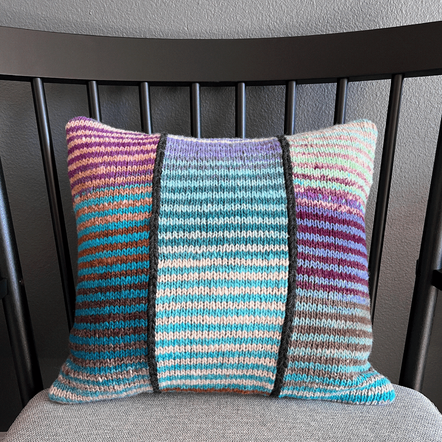 This 100% wool, hand-knit decorative throw pillow with variegated stripes brings a pop of color to any living space.
