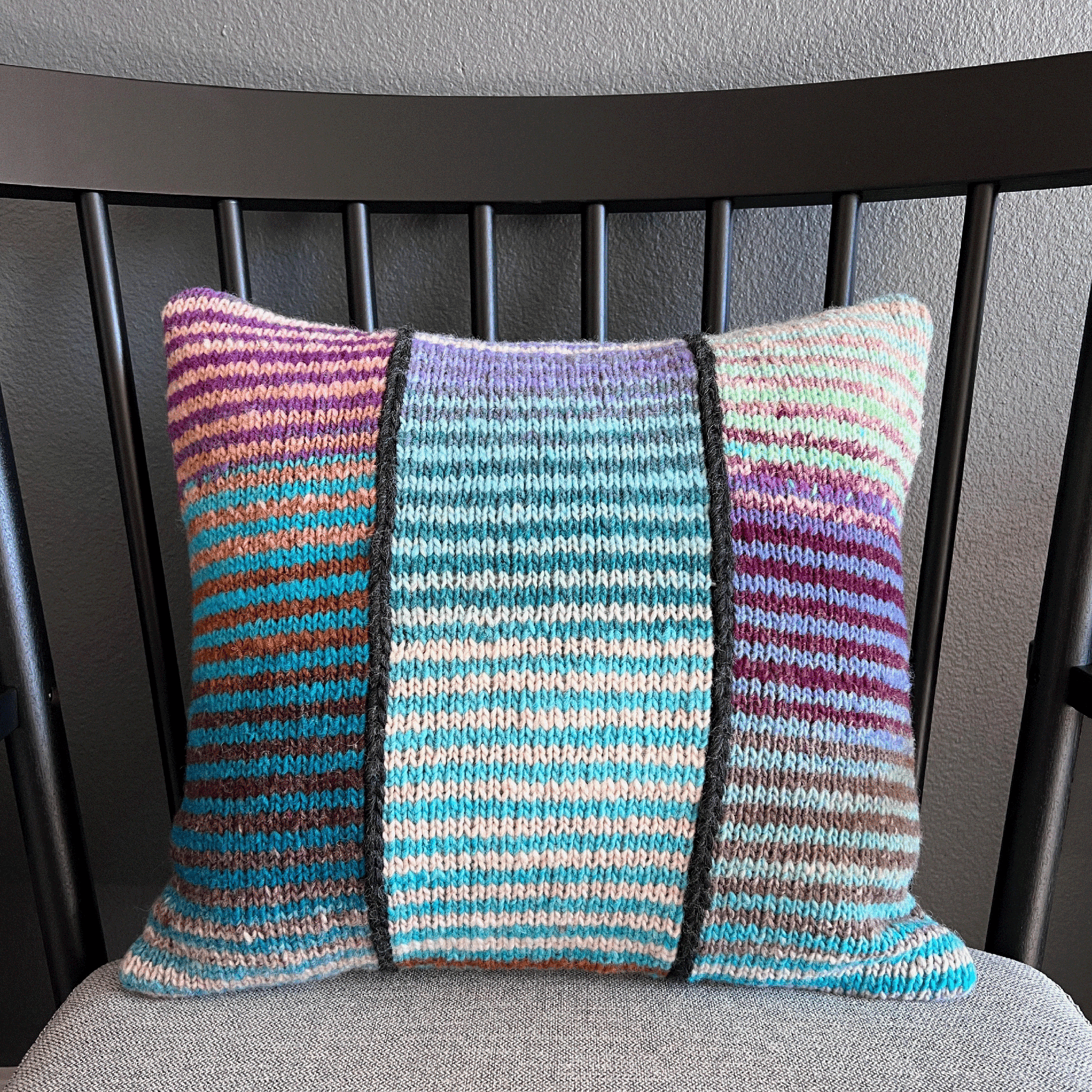 This 100% wool, hand-knit decorative throw pillow with variegated stripes brings a pop of color to any living space.