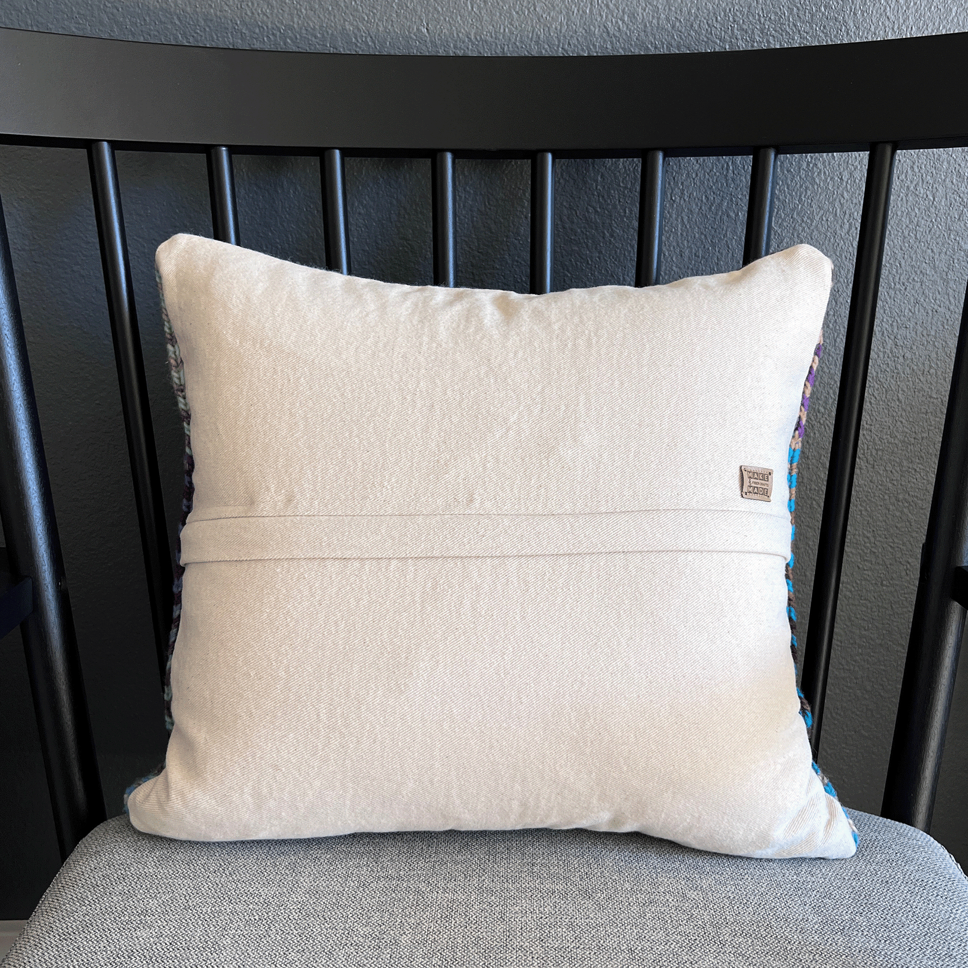 Backed in natural bull denim, this colorful, handcrafted throw pillow would look great in any living space, from family room to bedroom.