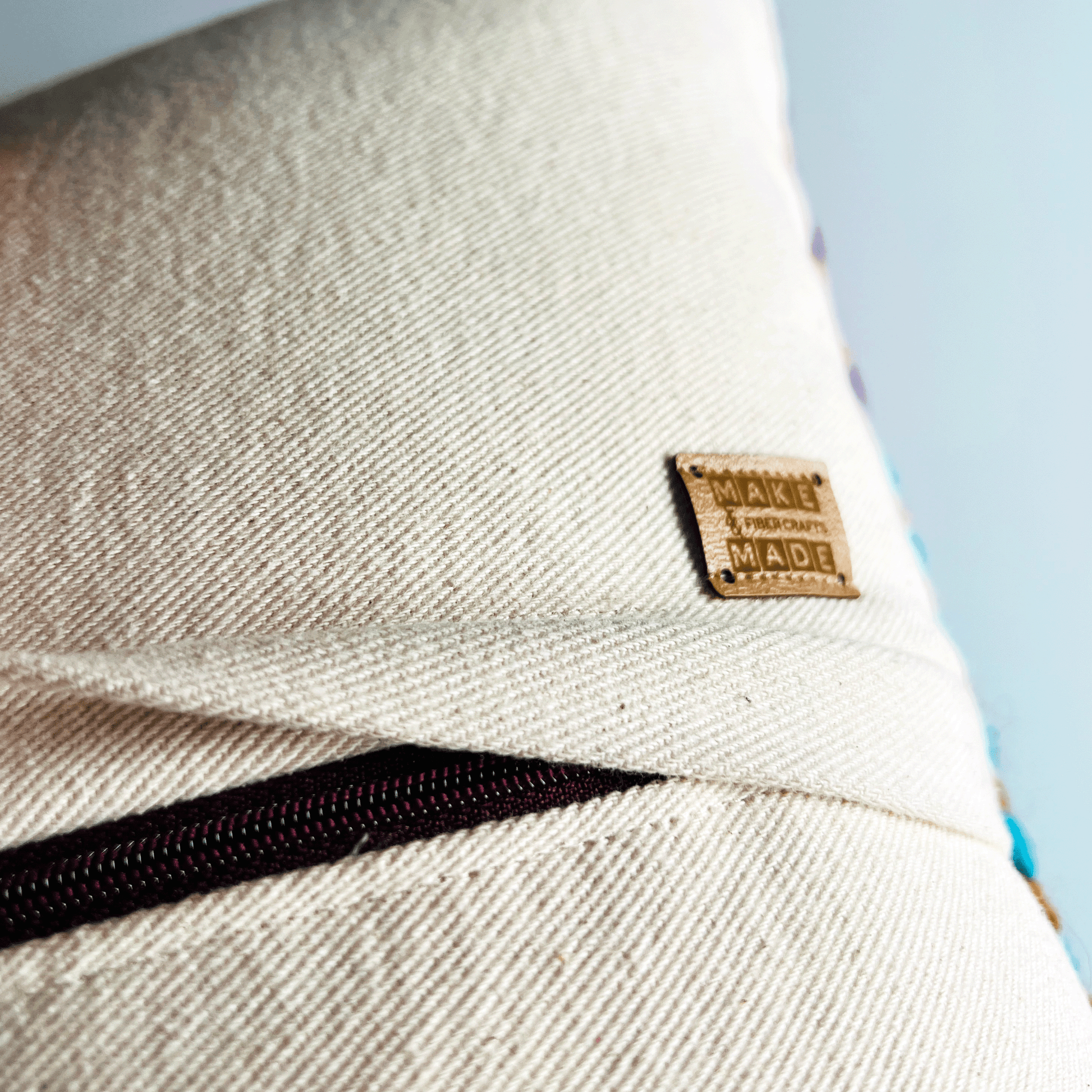 A dark wine zipper hides beneath a 1 inch flap, rendering this hand-sewn pillow cover easy to remove for spot cleaning.