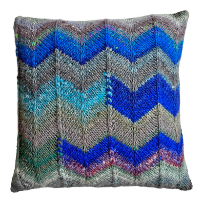 The front of this decorative pillow is charachterized by an asymetrical chevron design, created by alternating two Noro Kuryon colorways.