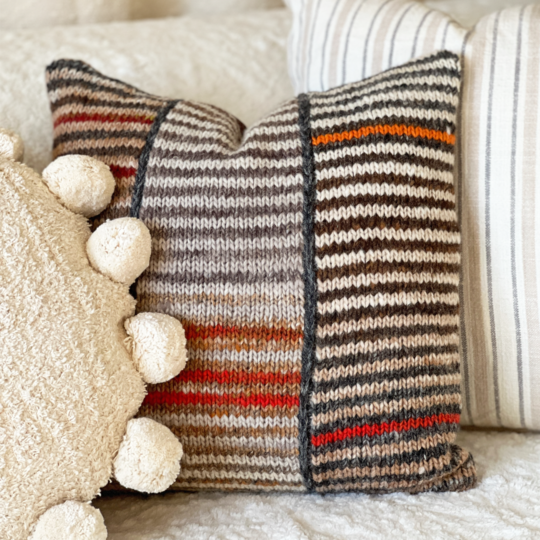 No matter which way you turn it, this hand-knit pillow looks great against an off-white or neutral-colored couch.