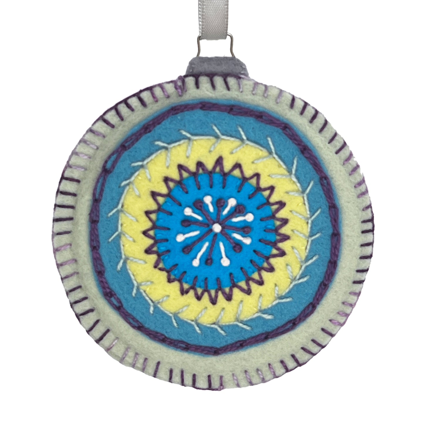 Ornament made from 100% wool felt, displaying concentric circles of mineral green, blue, and lime, embellished with detailed hand embroidery.