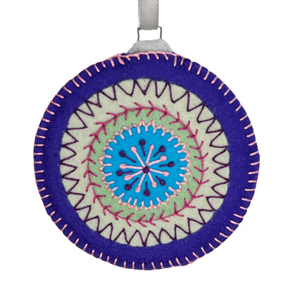 Ornament made from wool felt, displaying concentric circles of purple, mint green, and turquoise, embellished with detailed hand embroidery.