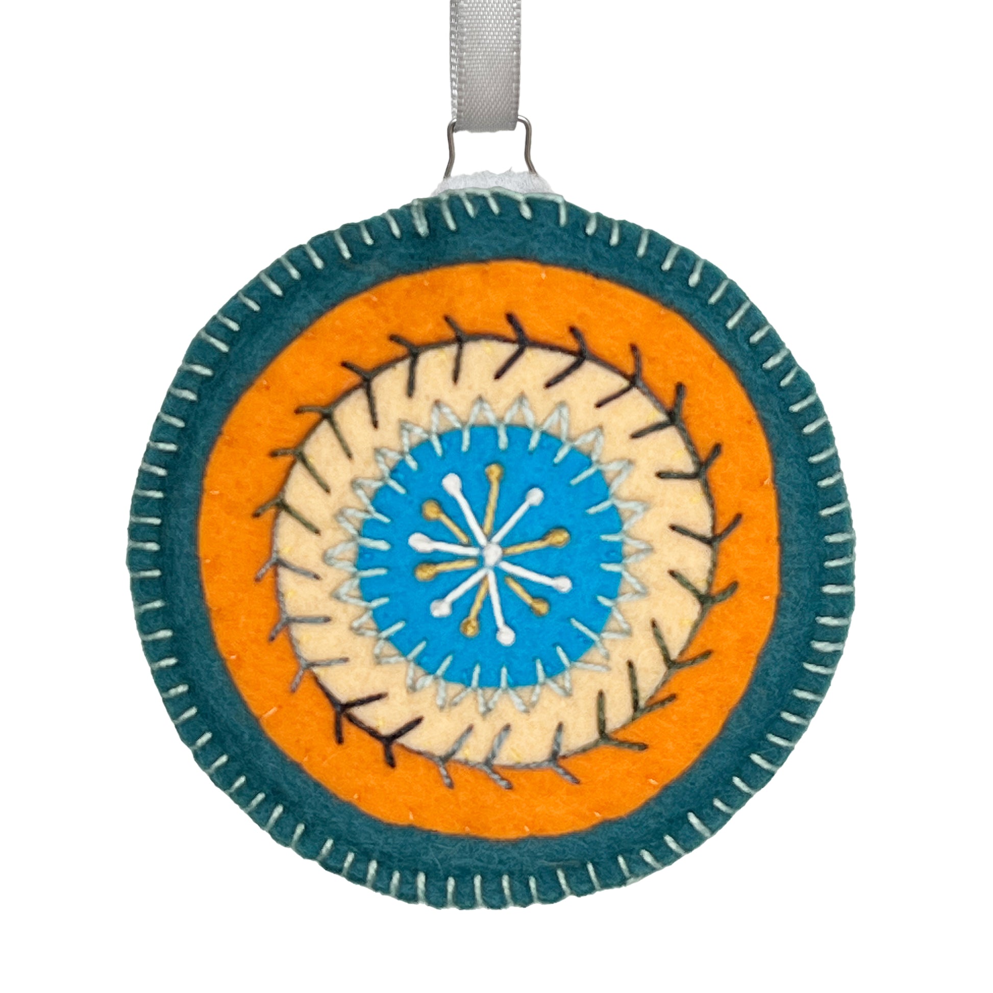 Wool felt ornament displaying concentric circles of teal, orange, peach, and blue, embellished with detailed hand embroidery.