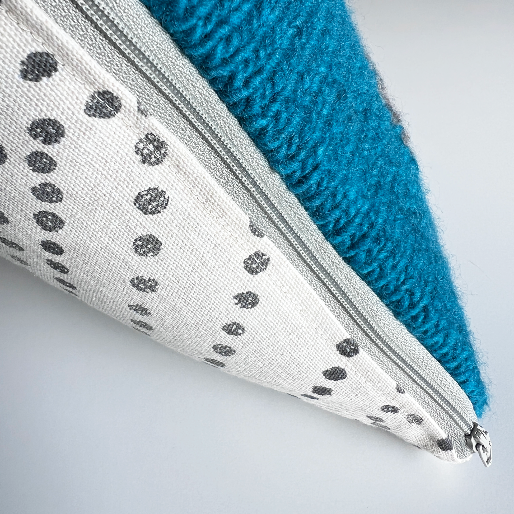 A complementary light gray zipper makes this pillow cover easy to remove for spot cleaning.