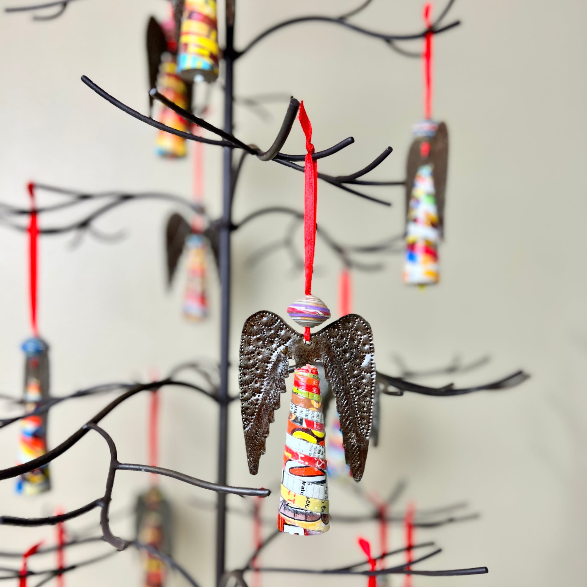 Each Haitian Angel steel drum ornament is a handcrafted piece of art, made by skilled artisans in Croix-des-Bouquets, Haiti. Shown here hanging from a wrought iron Christmas tree.