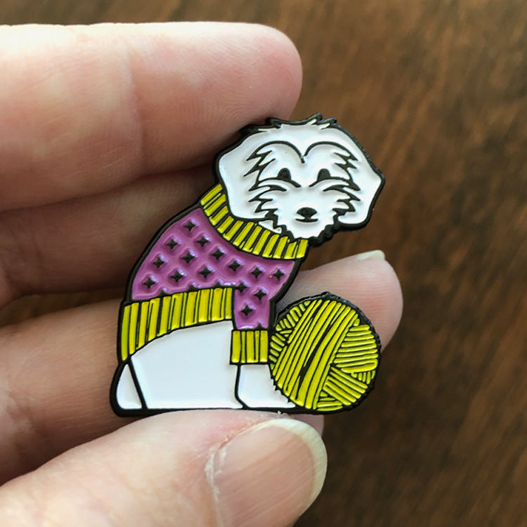 A hand holding Izzy Knits' Exclusive Izzy Enamel Pin to show size